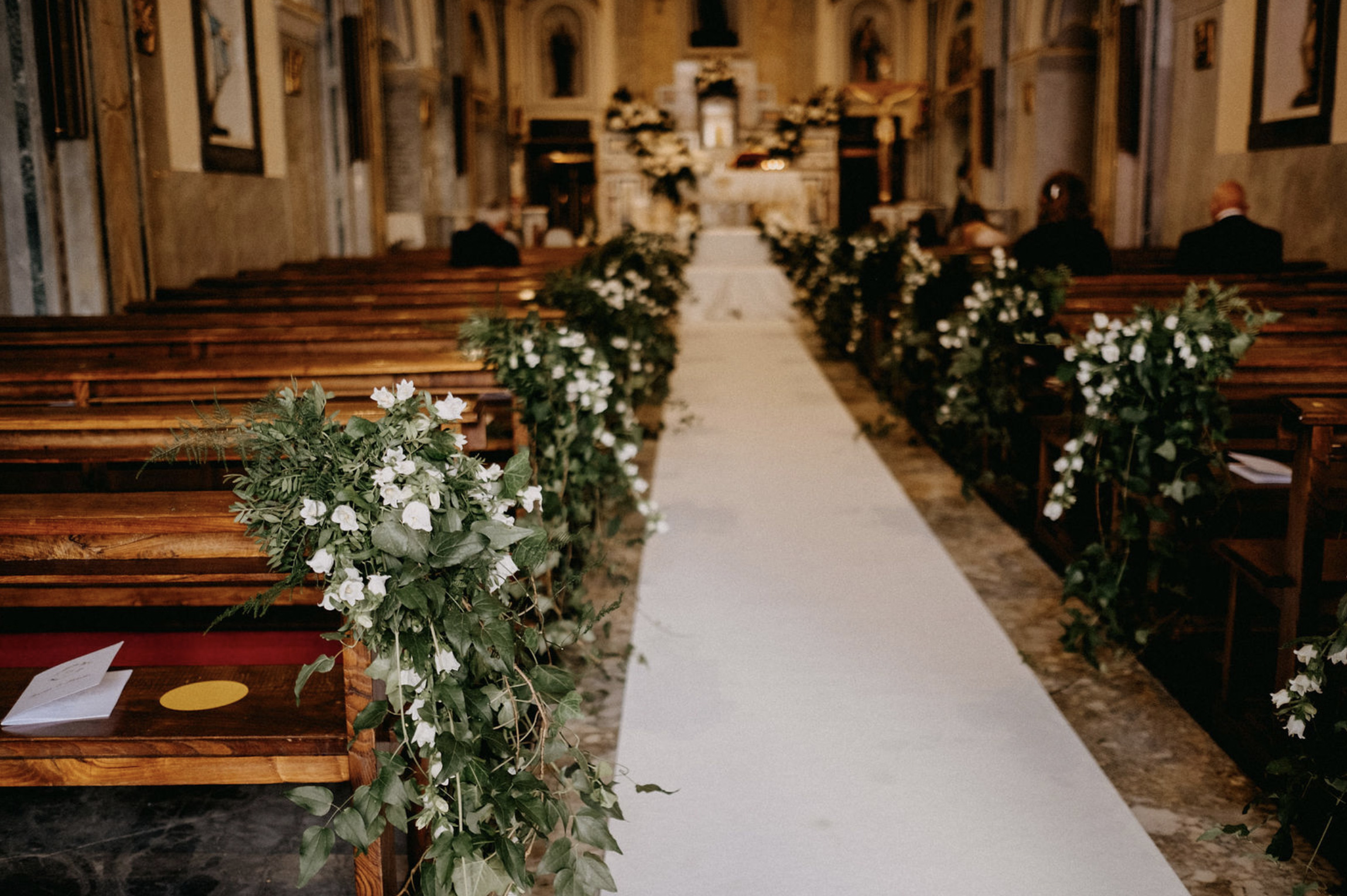 Allestimento floreale per navata della chiesa in stile botanico, con edera e campanule bianche